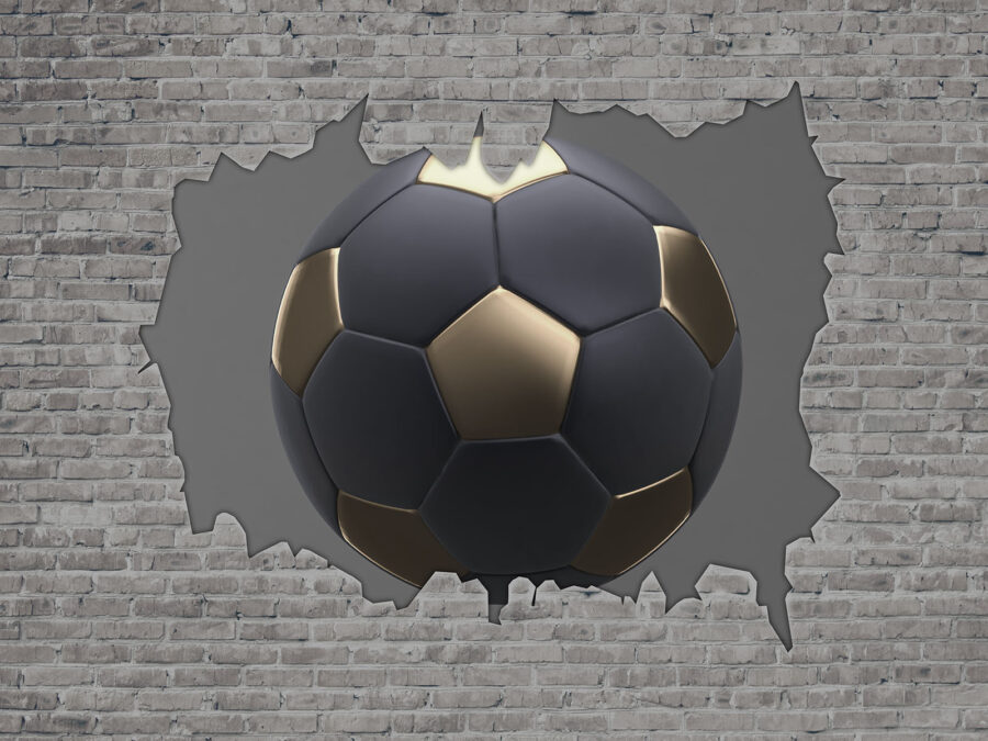 Un balón de fútbol atraviesa una pared