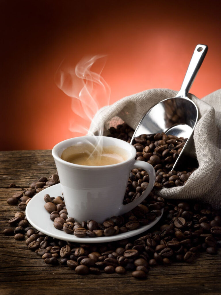 Taza de café con vapor y granos de café Taza de café con vapor y granos de café