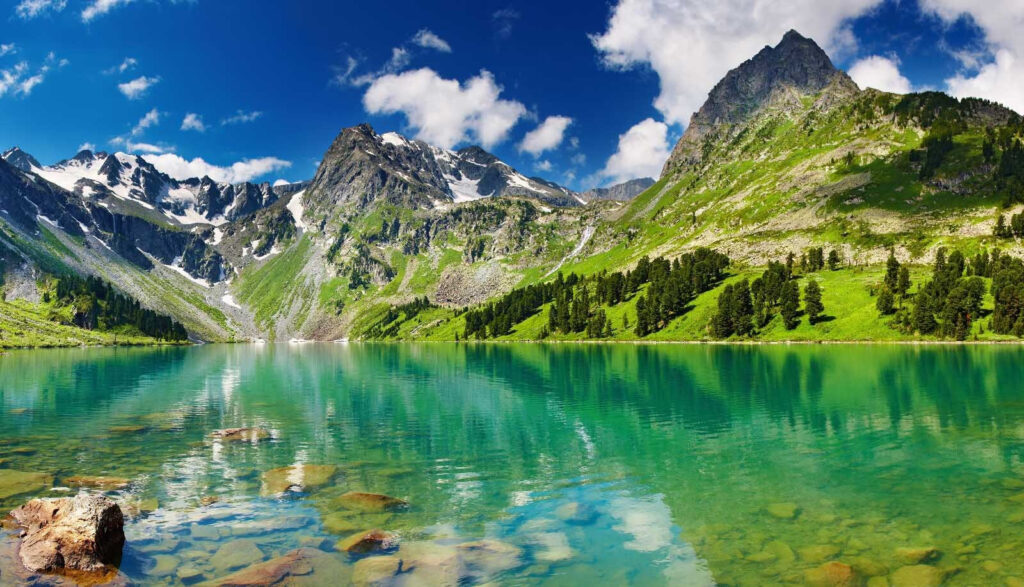 Masa de agua con montañas y árboles Masa de agua con montañas y árboles