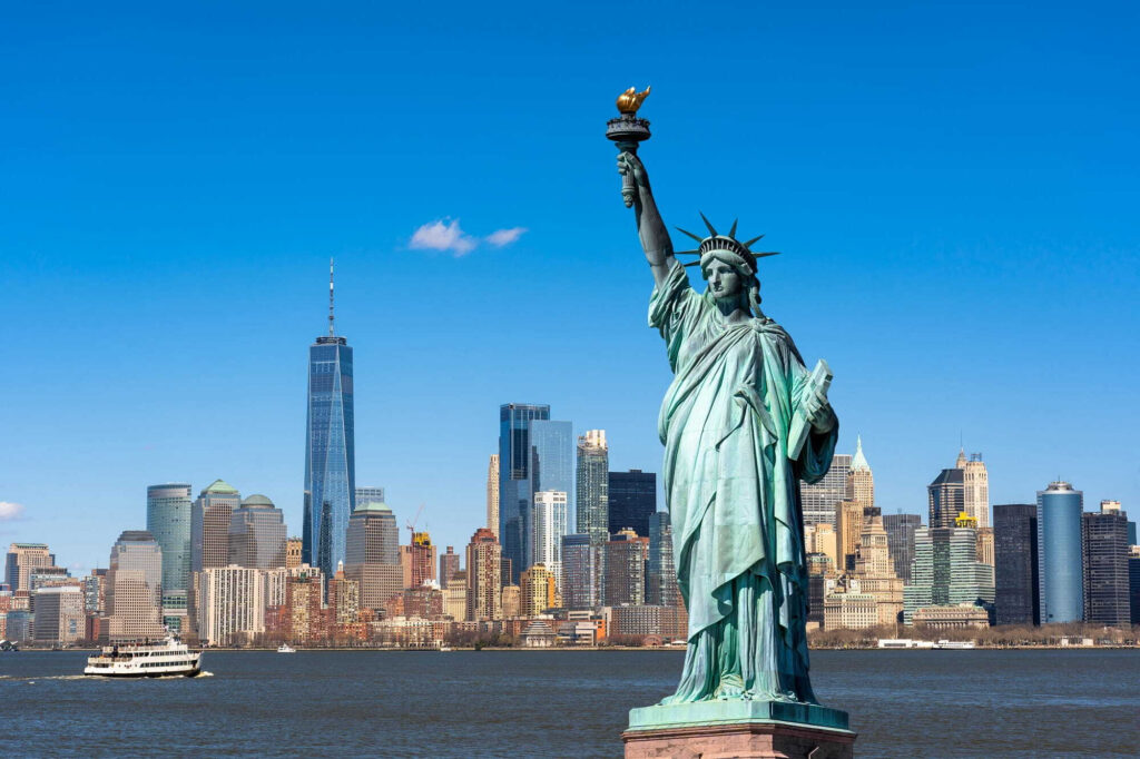 Estatua de la libertad con una ciudad al fondo Estatua de la libertad con una ciudad al fondo