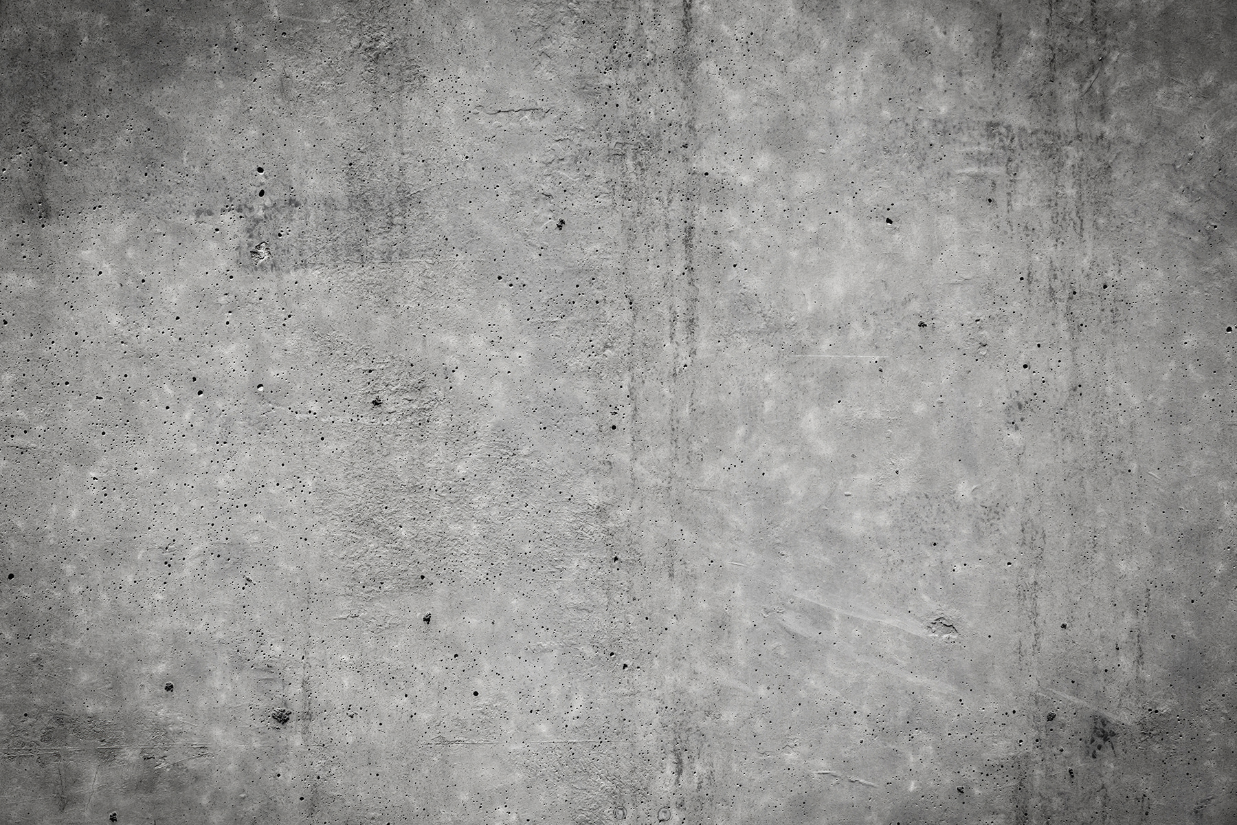 Grey concrete wall with black spots Grey concrete wall with black spots