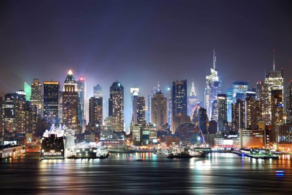 El horizonte de la ciudad de noche con luces reflejándose en el agua El horizonte de la ciudad de noche con luces reflejándose en el agua