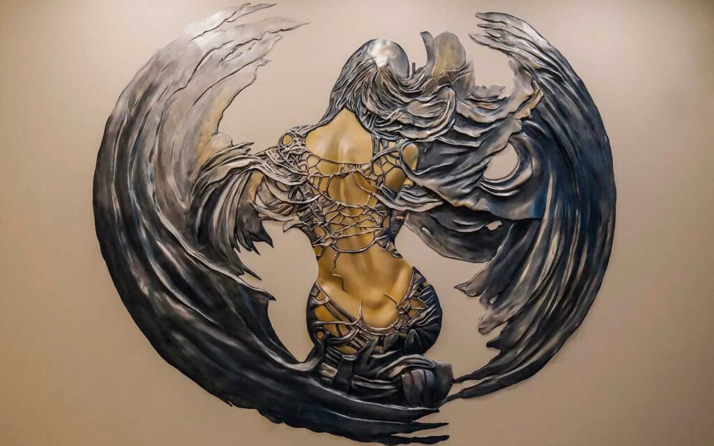 Escultura de metal de una mujer con alas Escultura de metal de una mujer con alas