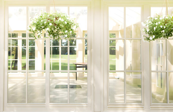 Puerta de patio blanca con ventanas de cristal y una maceta de ella Puerta de patio blanca con ventanas de cristal y una maceta de ella