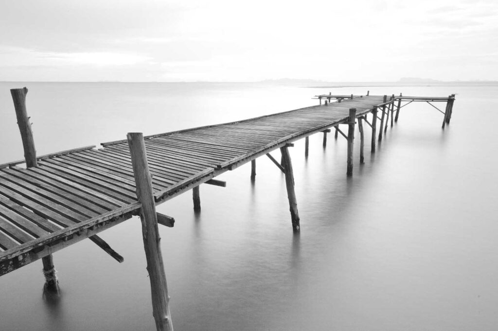 Largo puente de madera sobre el agua Largo puente de madera sobre el agua