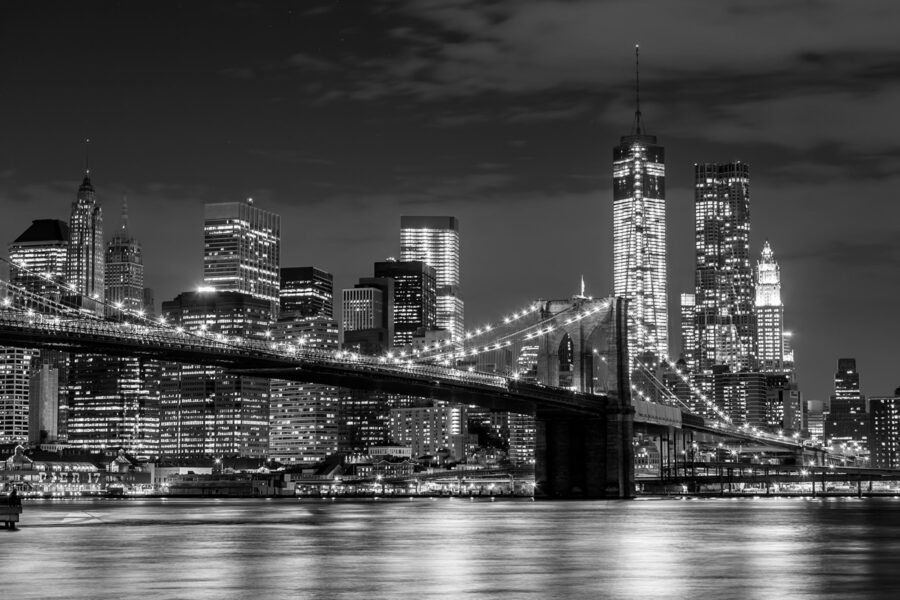 Puente sobre el agua con el perfil de la ciudad de noche