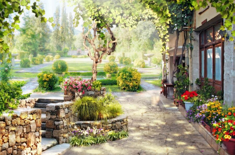 Paseo de piedra con un árbol y flores