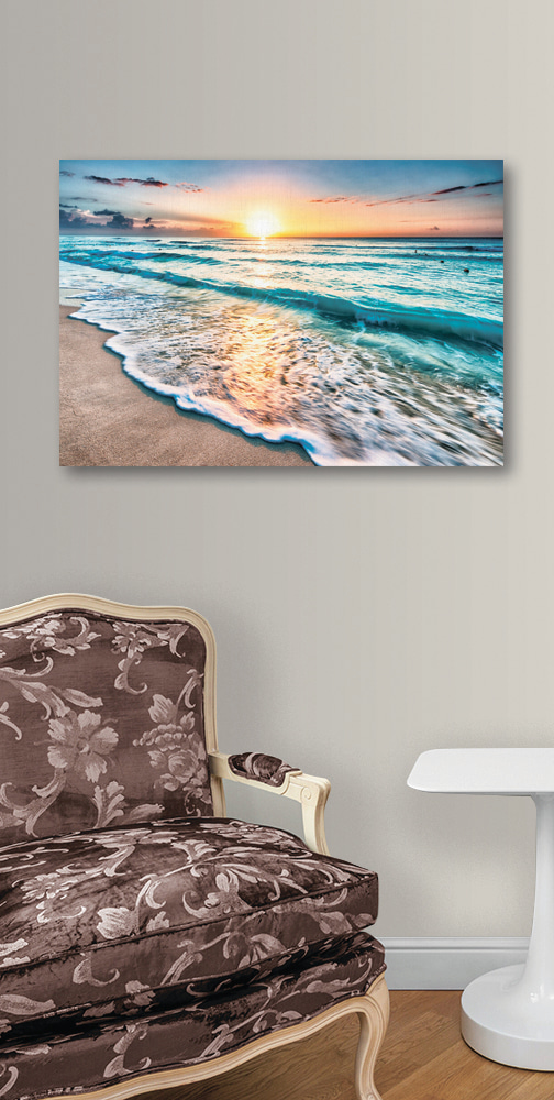 Cuadros Una playa con olas y una puesta de sol