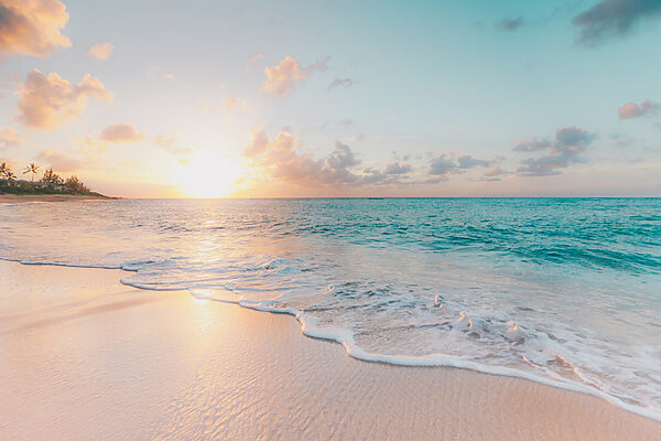 A beach with waves and a sunset