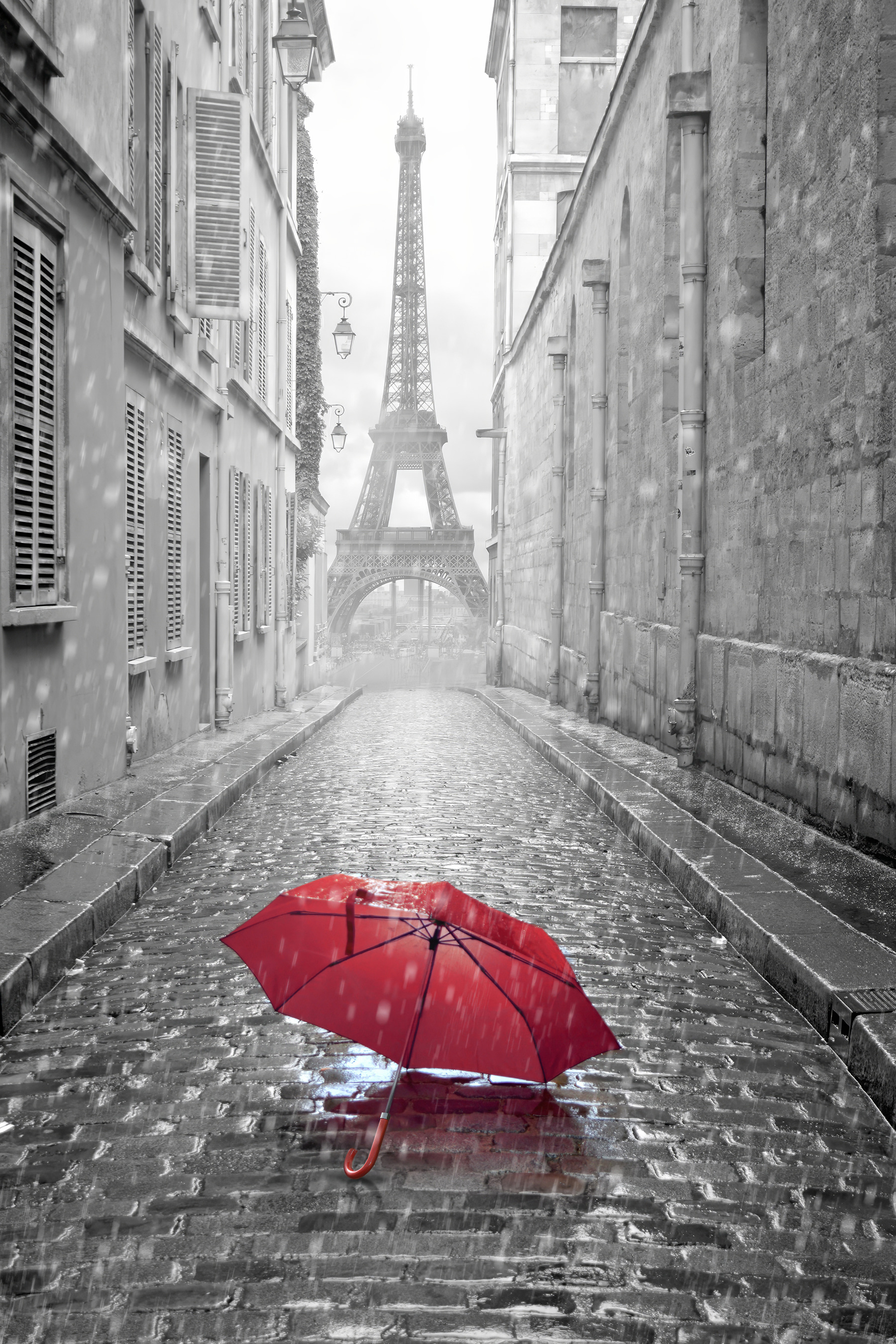 A red umbrella in a street with a tower in the background