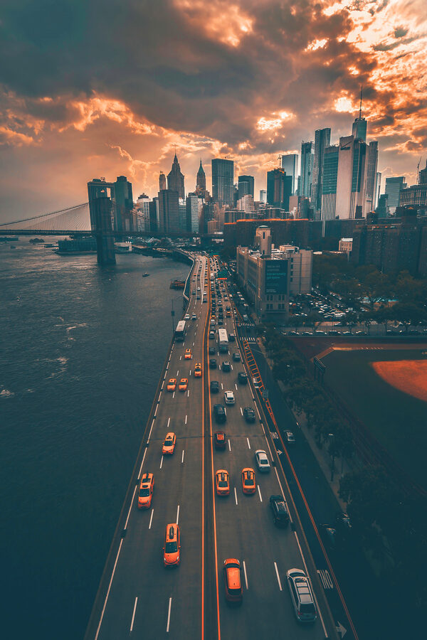 A bridge over water with cars and buildings in the background A bridge over water with cars and buildings in the background