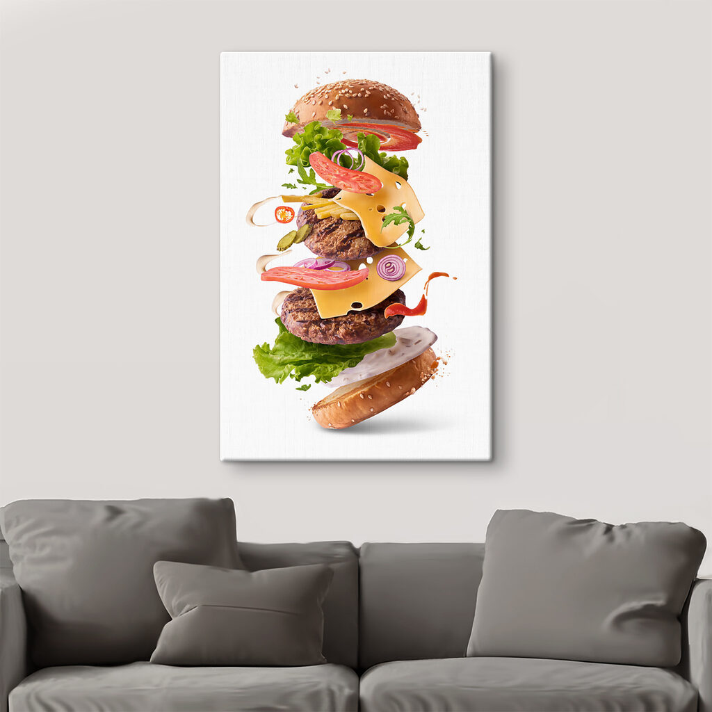 A hamburger with meat and vegetables flying in the air