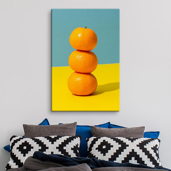 A stack of oranges on a yellow and blue surface