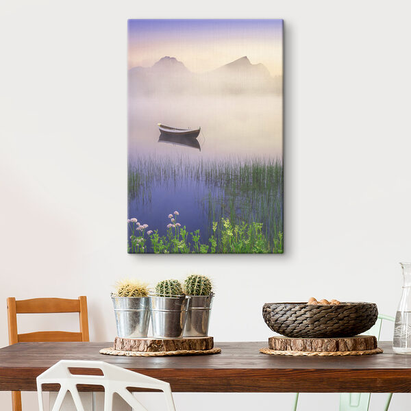 A boat in a lake with grass and mountains in the background A boat in a lake with grass and mountains in the background