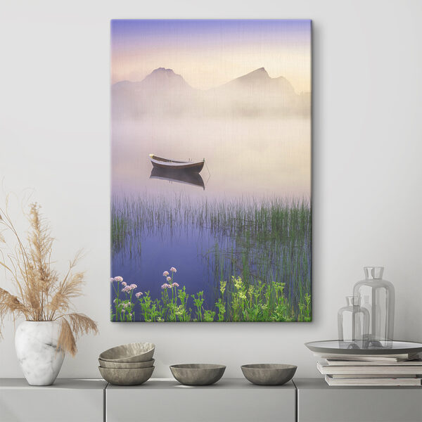 A boat in a lake with grass and mountains in the background A boat in a lake with grass and mountains in the background