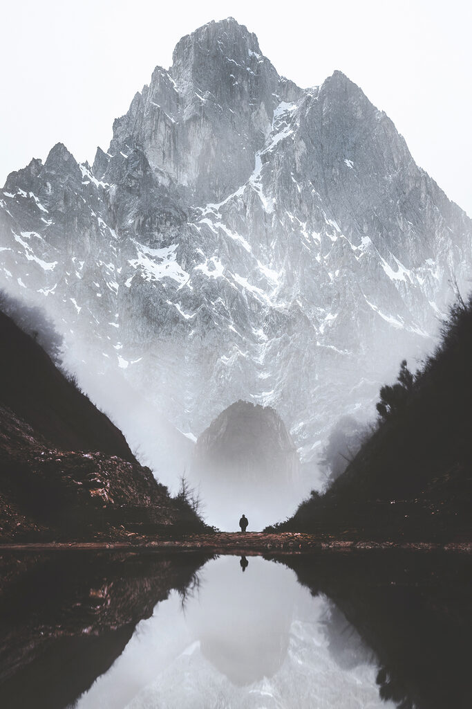 A person standing in a valley with a mountain in the background