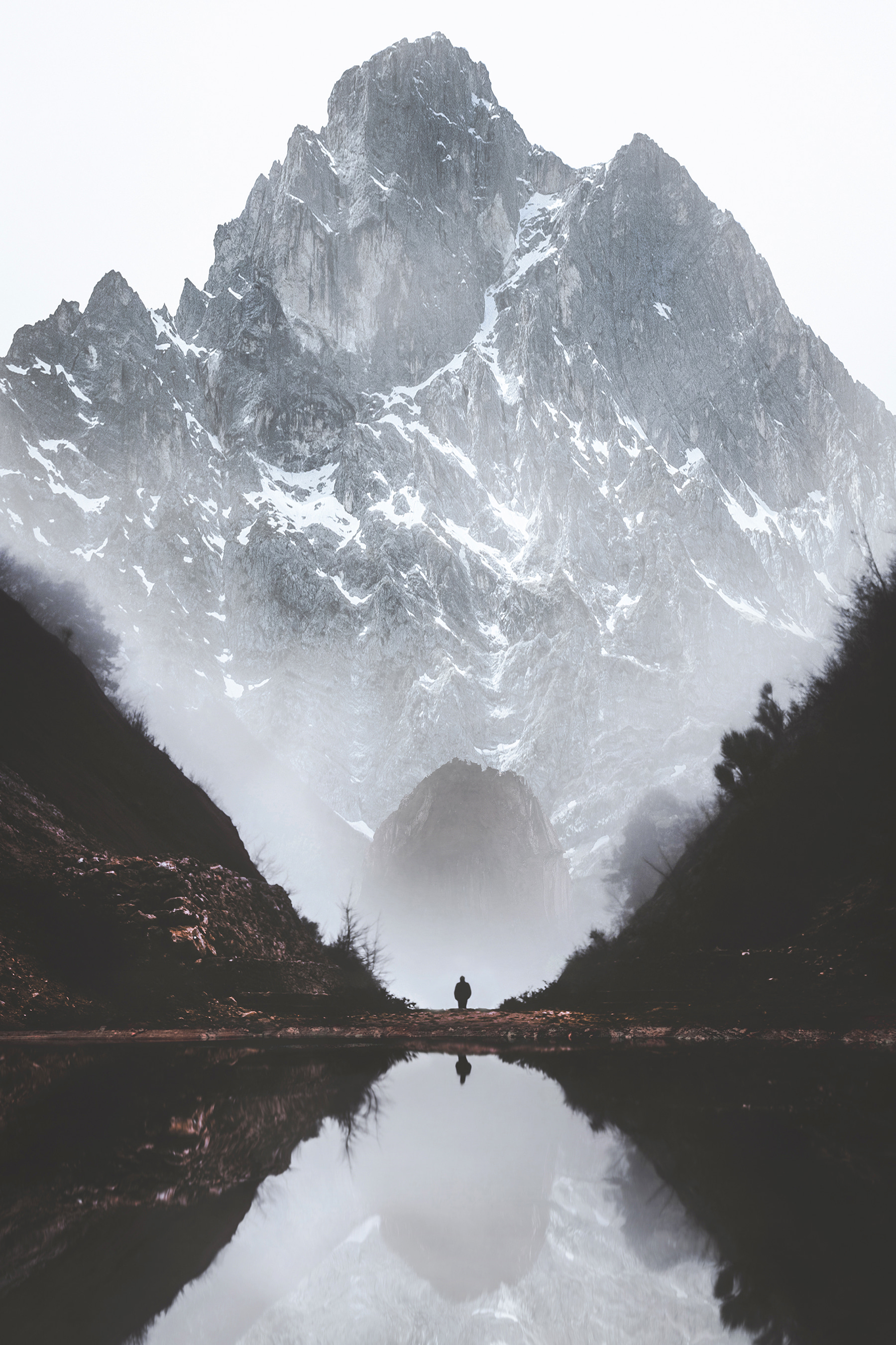 A person standing in a valley with a mountain in the background