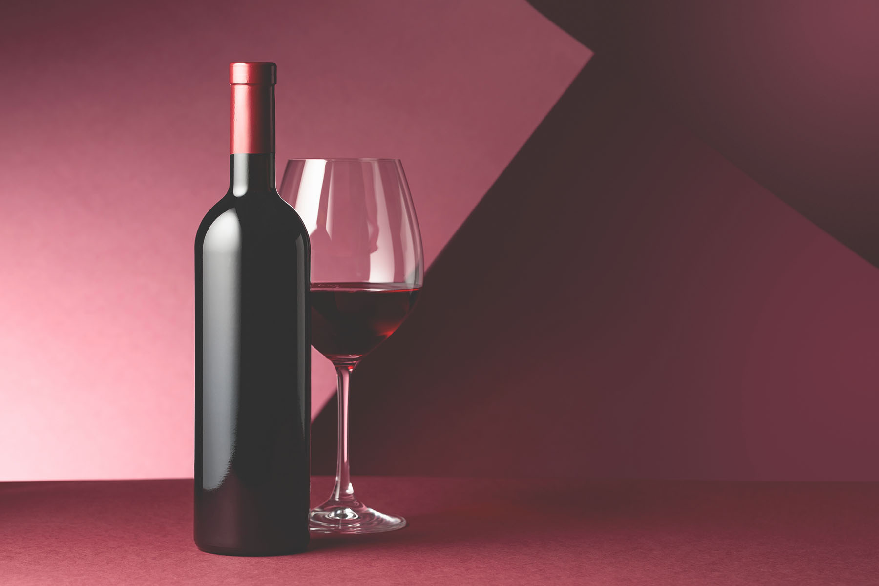A bottle of wine next to a glass of wine A bottle of wine next to a glass of wine