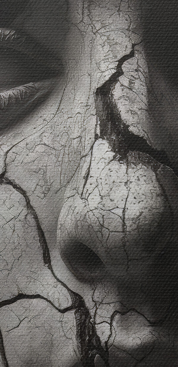 A statue of a woman with a cracked face and snakes around her face