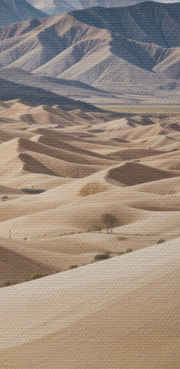 Large sandy hills with mountains in the background