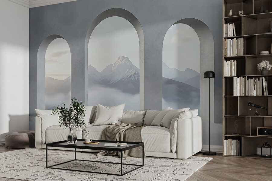 Habitación blanca con ventanas arqueadas y montañas al fondo