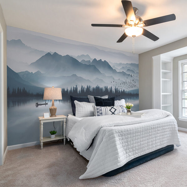 Person in a boat on a lake with mountains in the background Person in a boat on a lake with mountains in the background
