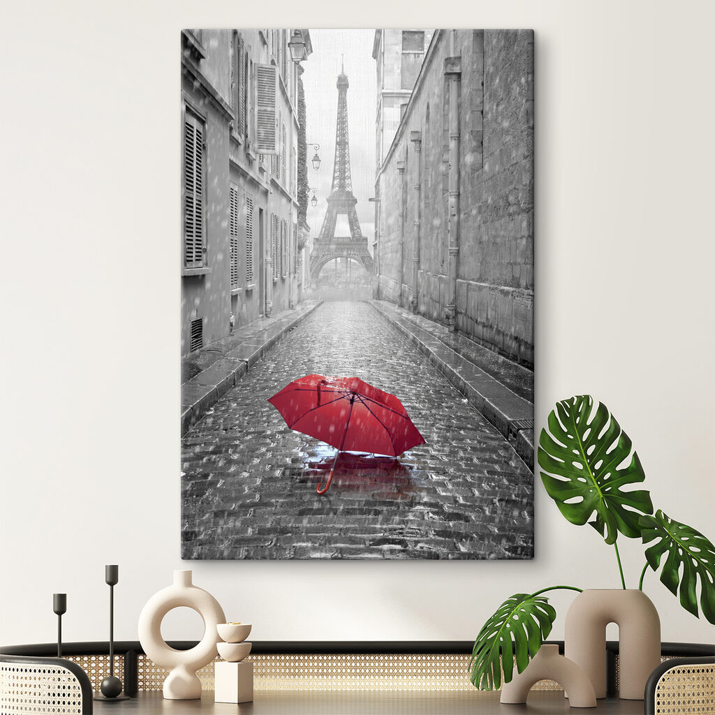 A red umbrella in a street with a tower in the background