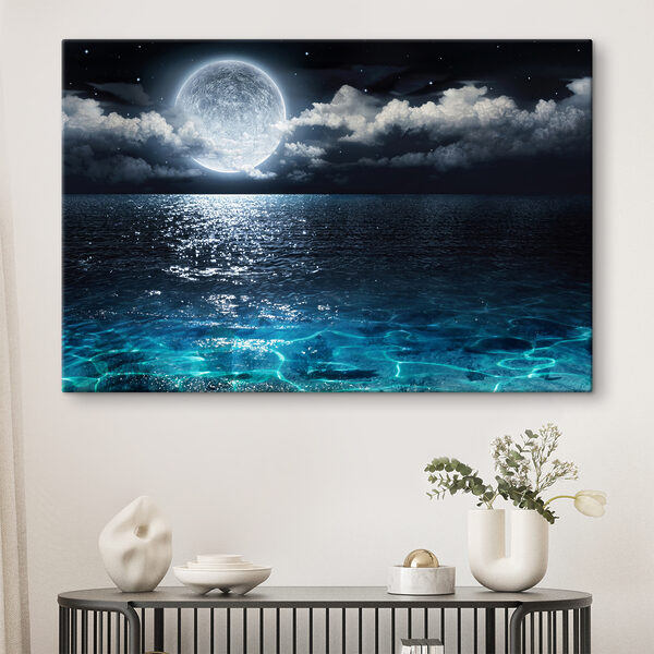 A moon over water at night