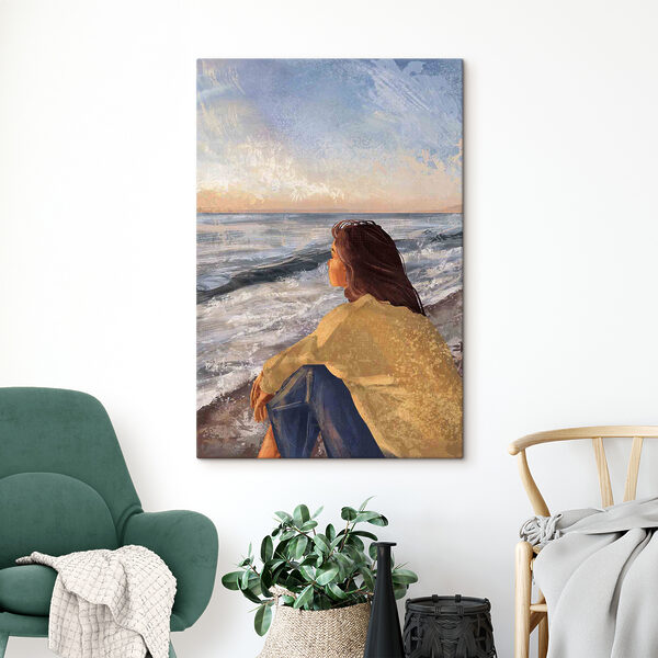 A woman sitting on a beach looking out to the ocean A woman sitting on a beach looking out to the ocean