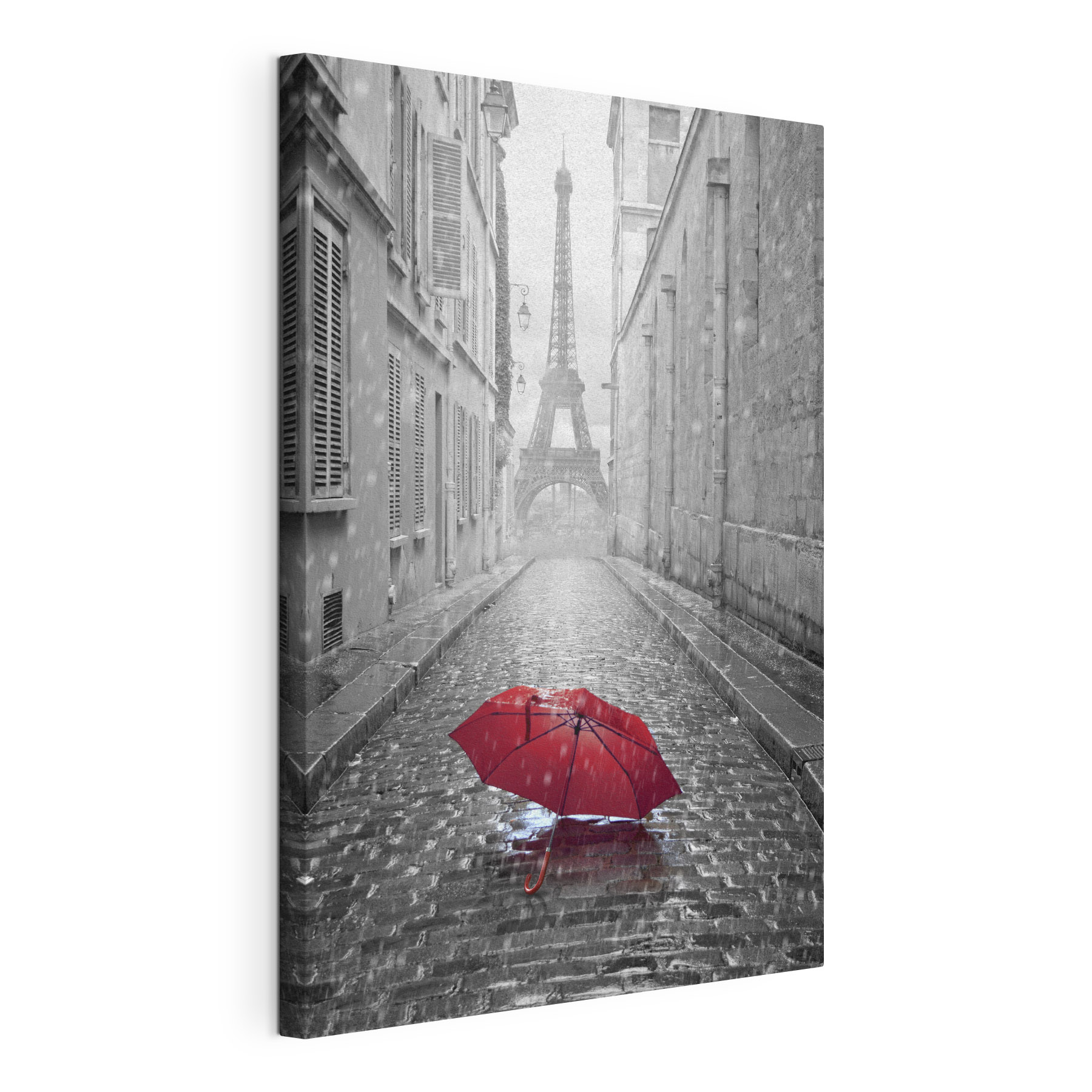 A red umbrella in a street with a tower in the background